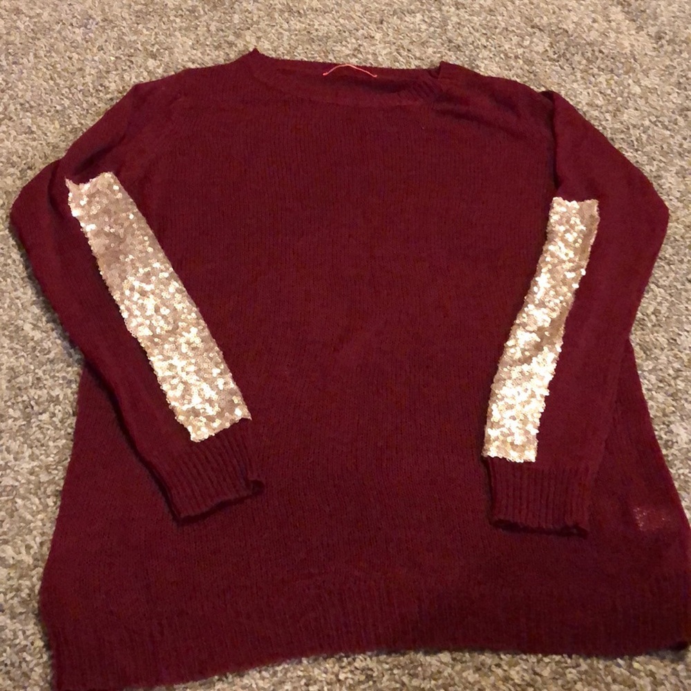 Red sweater with sequin arms.